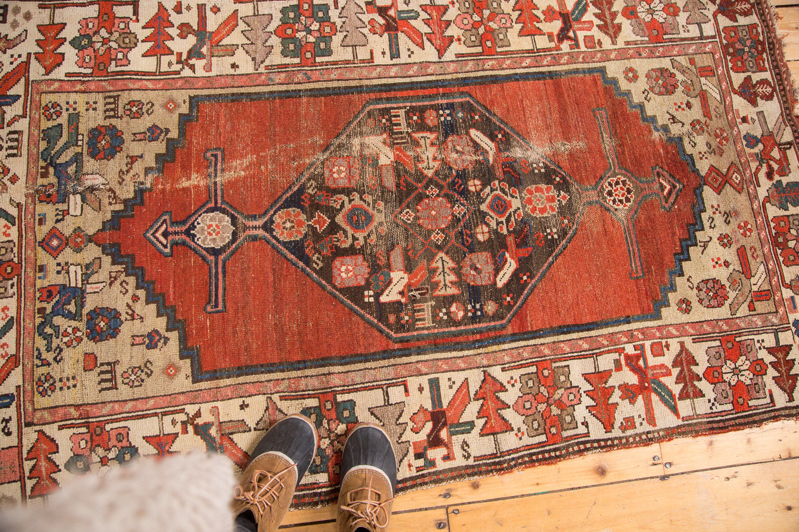 Distressed cherry red field and tribal spandrel motifs on a vintage Kurdish Hamadan rug.